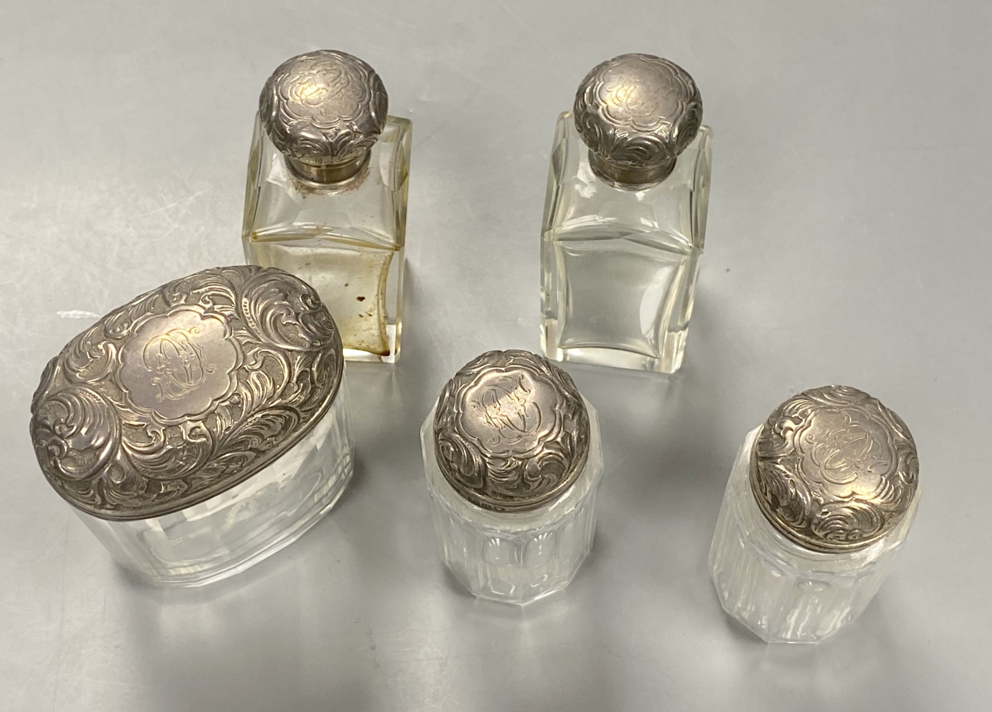 Five silver lidded powder bottles